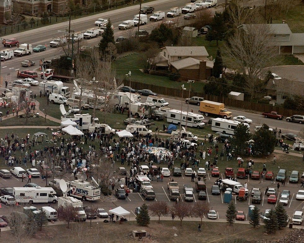 Several camera crews, reporters, and journalists arrive at Columbine High School.