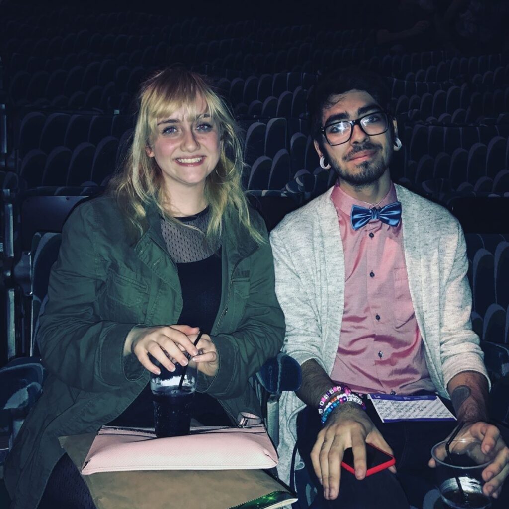 Emma and Javier sitting in their seats at the theatre.