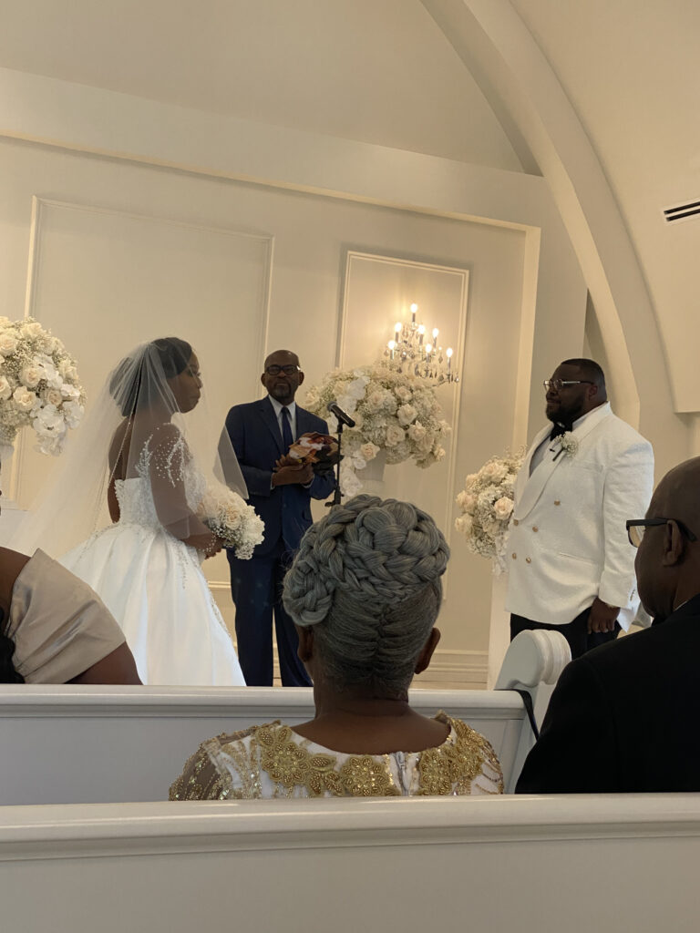 Couple at the altar where the bride is on the left and the groom is on the right, and the officiant in the middle