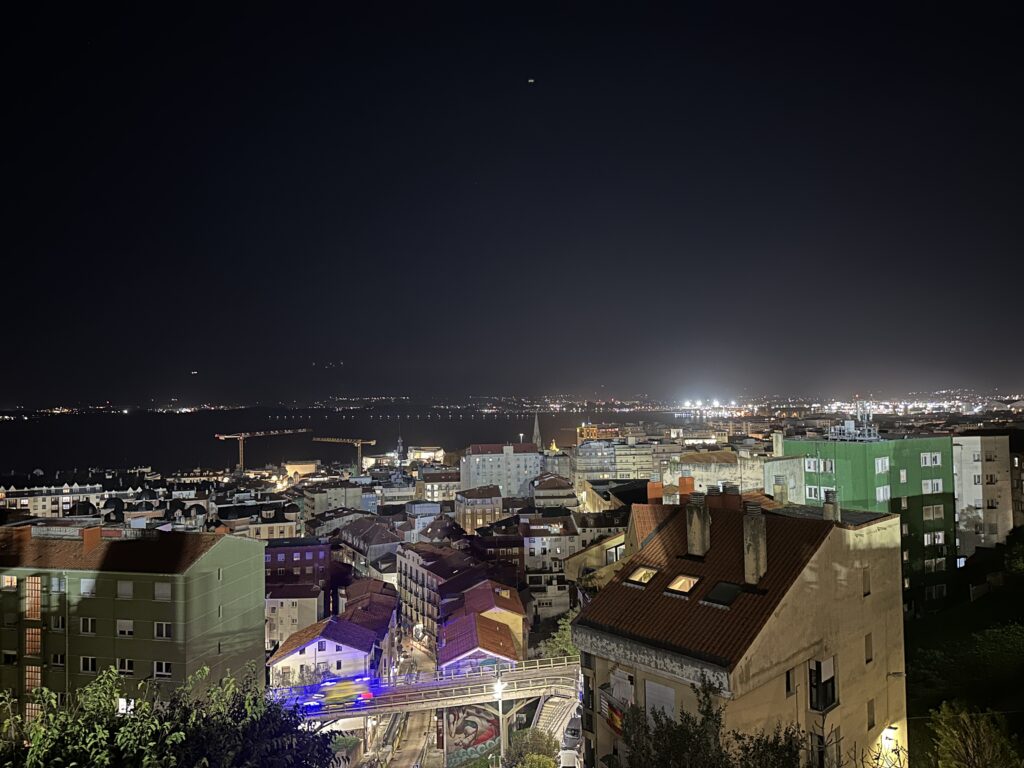 Cityscape of buildings in front of sky at night time.